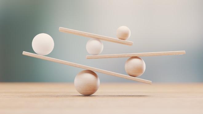 A precariously balanced pile of ping-pong balls and wooden bars.