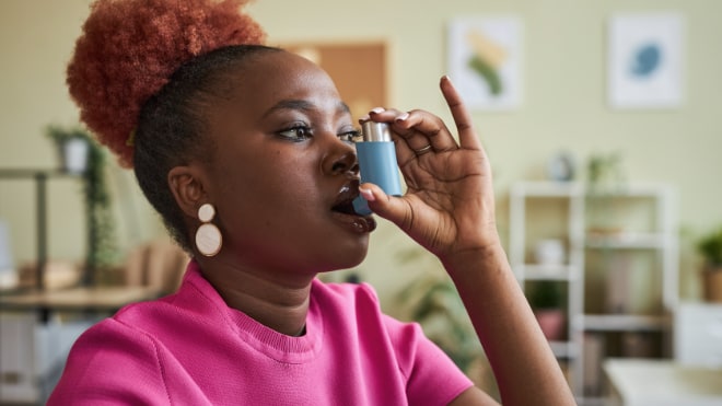 A woman uses an inhaler.